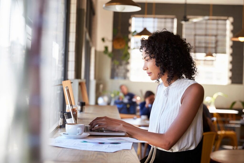 Woman working on laptop in a cafe.