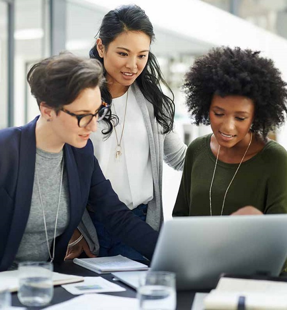 Three women looking at a laptop screen